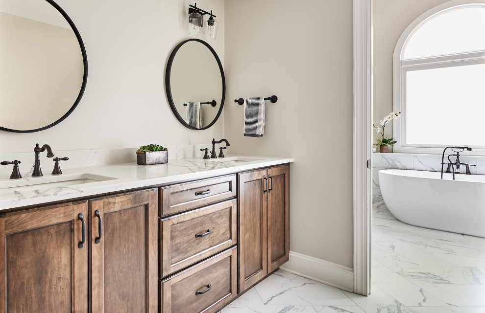 Inredning av ett klassiskt en-suite badrum, med luckor med infälld panel, bruna skåp, ett badkar i en alkov, svart och vit kakel, porslinskakel och klinkergolv i porslin