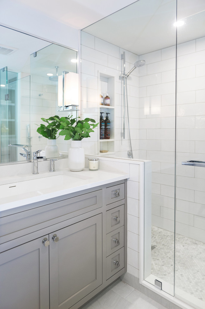 Design ideas for a medium sized traditional ensuite bathroom in Toronto with shaker cabinets, grey cabinets, an alcove shower, a one-piece toilet, white tiles, ceramic tiles, white walls, porcelain flooring, a submerged sink, engineered stone worktops, white floors and a hinged door.