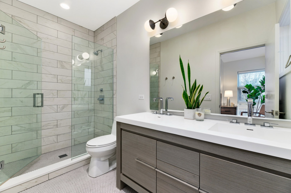 Exemple d'une grande salle de bain tendance en bois brun avec un placard à porte plane, un carrelage gris, des carreaux de porcelaine, un lavabo intégré, une cabine de douche à porte battante, un plan de toilette blanc, meuble double vasque et meuble-lavabo encastré.