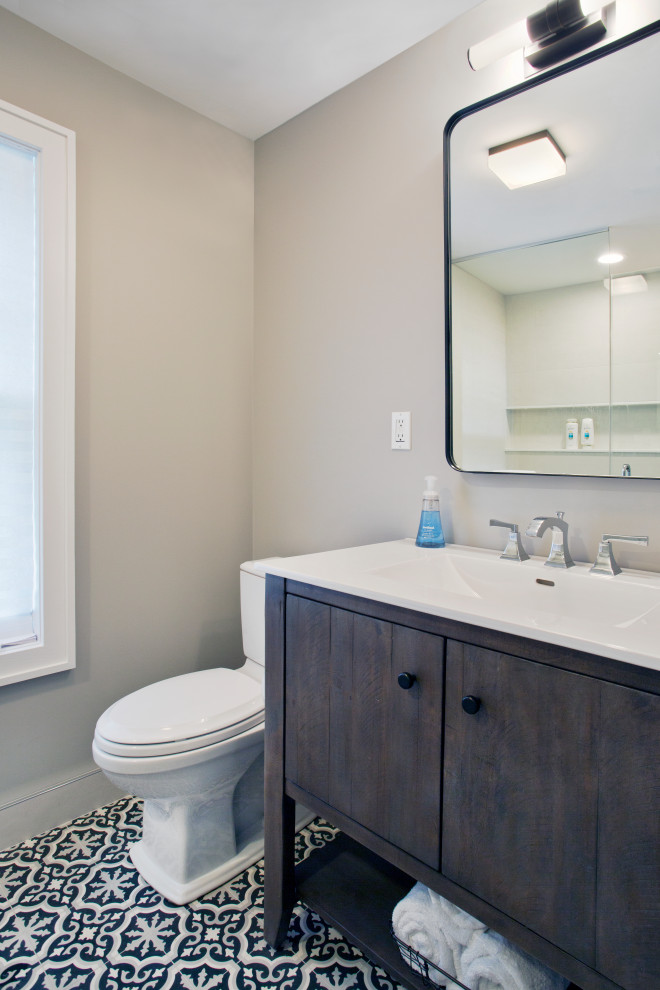 Bild på ett litet vintage vit vitt en-suite badrum, med möbel-liknande, bruna skåp, en dusch i en alkov, en toalettstol med hel cisternkåpa, beige väggar, cementgolv, ett integrerad handfat, bänkskiva i akrylsten, flerfärgat golv och dusch med gångjärnsdörr