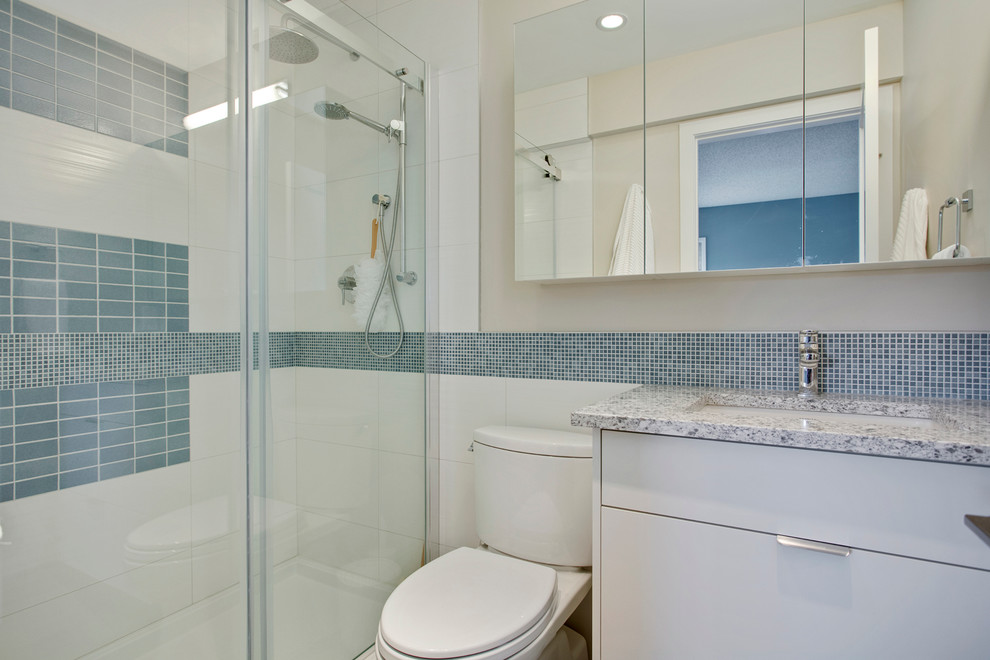 Ispirazione per una stanza da bagno con doccia contemporanea con ante lisce, ante grigie, doccia alcova, piastrelle blu, piastrelle bianche, piastrelle a mosaico, pareti beige, lavabo sottopiano e top in granito