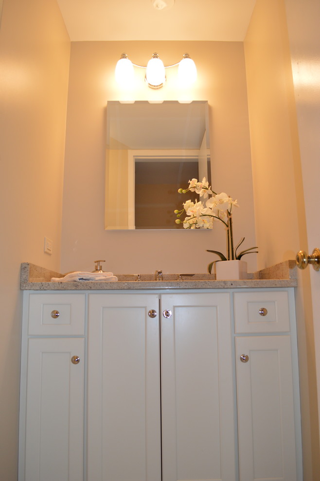 Imagen de cuarto de baño clásico pequeño con armarios con paneles empotrados, puertas de armario blancas, baldosas y/o azulejos beige, paredes beige, aseo y ducha, lavabo bajoencimera y encimera de granito