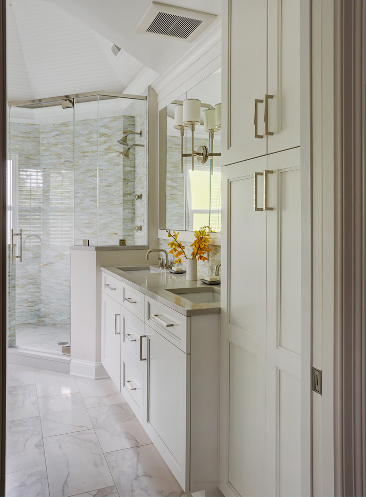 Example of a mid-sized transitional master multicolored tile and glass tile marble floor and white floor bathroom design in Chicago with recessed-panel cabinets, white cabinets, a one-piece toilet, gray walls, an undermount sink, quartz countertops, a hinged shower door and gray countertops
