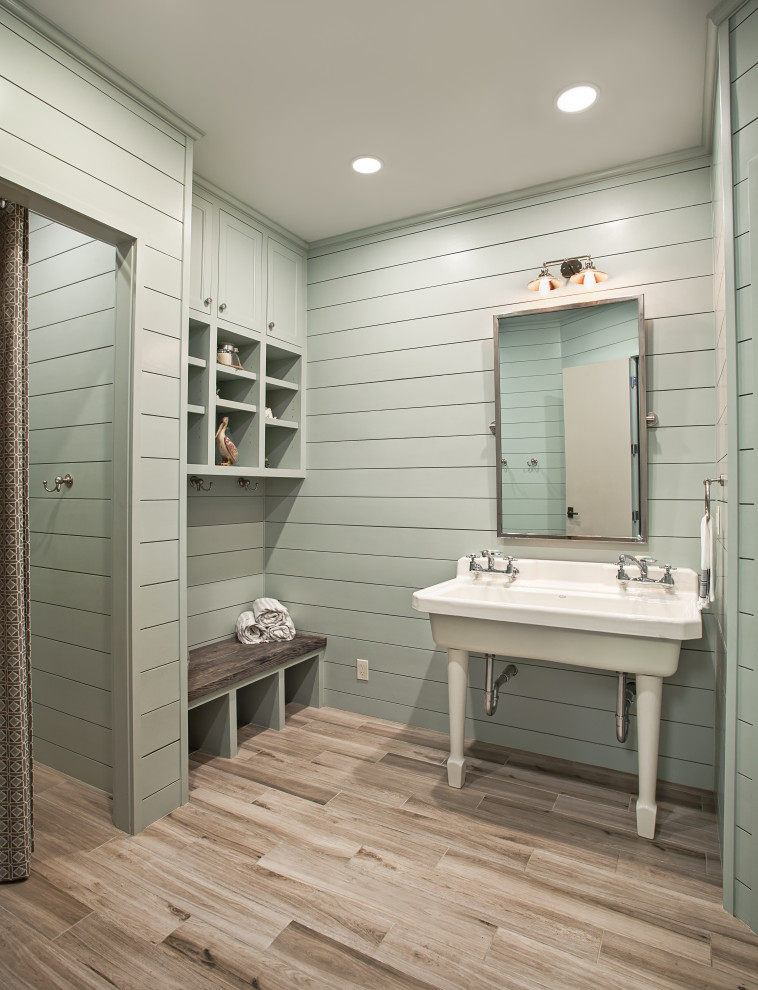 Modelo de cuarto de baño tradicional renovado grande con armarios abiertos, puertas de armario blancas, sanitario de dos piezas, paredes azules, suelo de baldosas de porcelana, lavabo tipo consola y suelo marrón