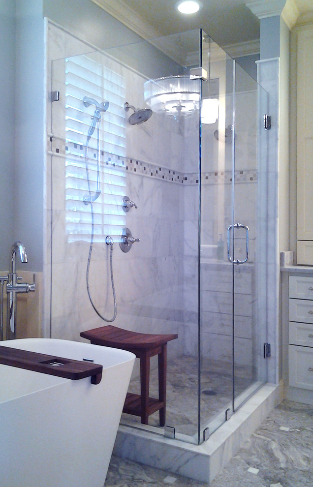 Idées déco pour une salle de bain principale classique de taille moyenne avec un lavabo encastré, un placard avec porte à panneau encastré, un plan de toilette en marbre, une baignoire indépendante, une douche d'angle, un carrelage beige, un carrelage de pierre, un mur bleu, un sol en marbre et des portes de placard blanches.