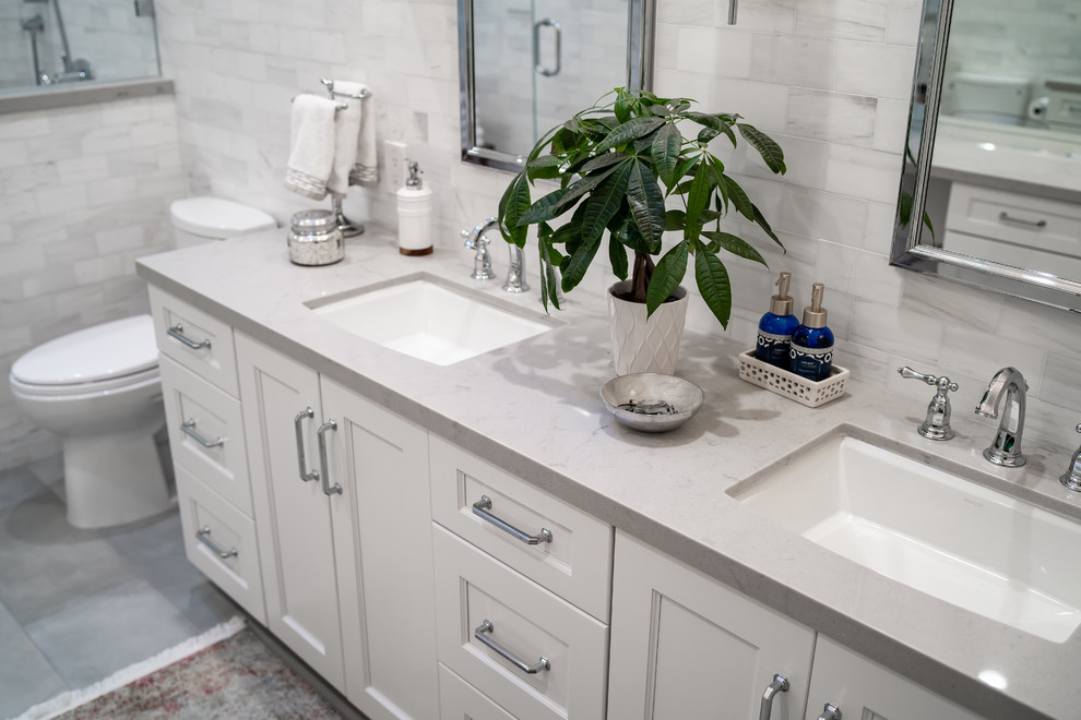 Пример оригинального дизайна: главная ванная комната среднего размера в стиле неоклассика (современная классика) с фасадами с утопленной филенкой, белыми фасадами, душем в нише, раздельным унитазом, белой плиткой, мраморной плиткой, серыми стенами, полом из цементной плитки, врезной раковиной, мраморной столешницей, серым полом, душем с распашными дверями и белой столешницей
