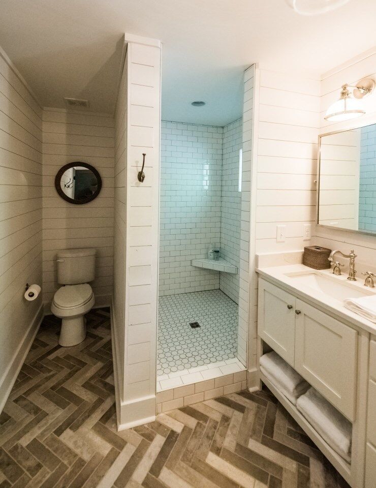 Lantlig inredning av ett mellanstort en-suite badrum, med skåp i shakerstil, vita skåp, en dusch i en alkov, vit kakel, tunnelbanekakel, vita väggar, marmorbänkskiva och med dusch som är öppen