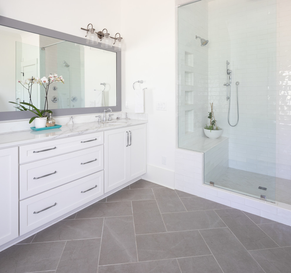 Inspiration for a large cottage master white tile and ceramic tile ceramic tile and gray floor alcove shower remodel in Nashville with shaker cabinets, white cabinets, white walls, marble countertops, a hinged shower door and white countertops