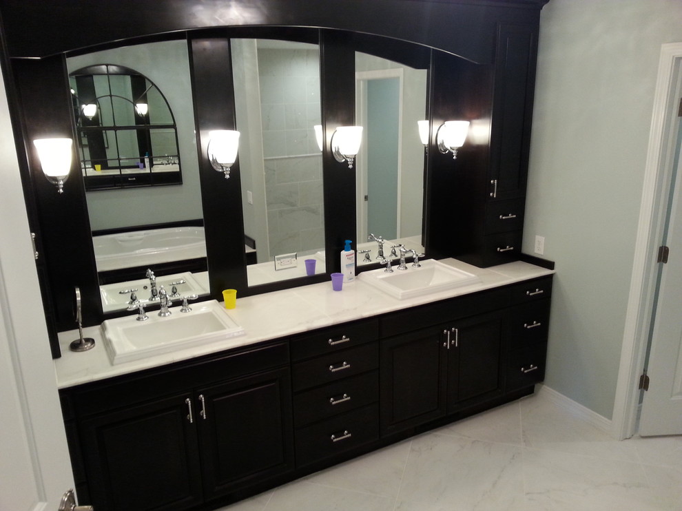 Foto de cuarto de baño principal de estilo americano grande con armarios tipo mueble, puertas de armario de madera en tonos medios, encimera de mármol, ducha abierta, paredes grises y suelo de mármol