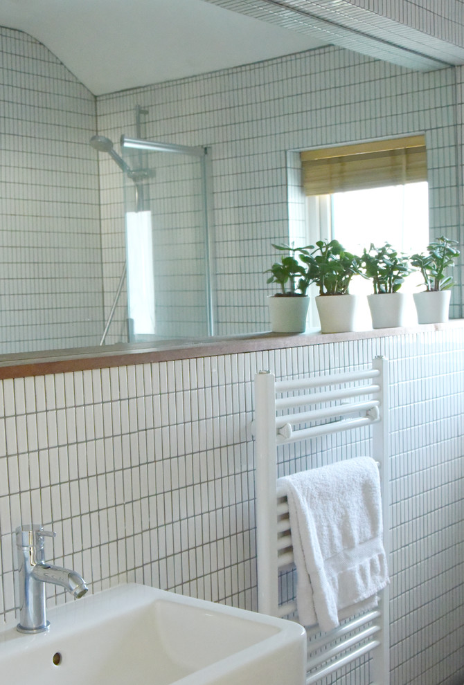Пример оригинального дизайна: маленькая детская ванная комната с плоскими фасадами, белыми фасадами, накладной ванной, душем над ванной, раздельным унитазом, белой плиткой, плиткой мозаикой, белыми стенами, пробковым полом и подвесной раковиной для на участке и в саду