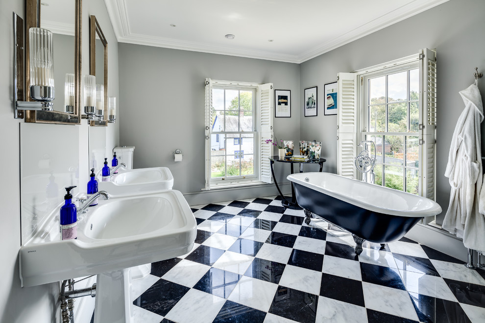 Diseño de cuarto de baño tradicional grande con bañera exenta, combinación de ducha y bañera, baldosas y/o azulejos blancas y negros y lavabo con pedestal