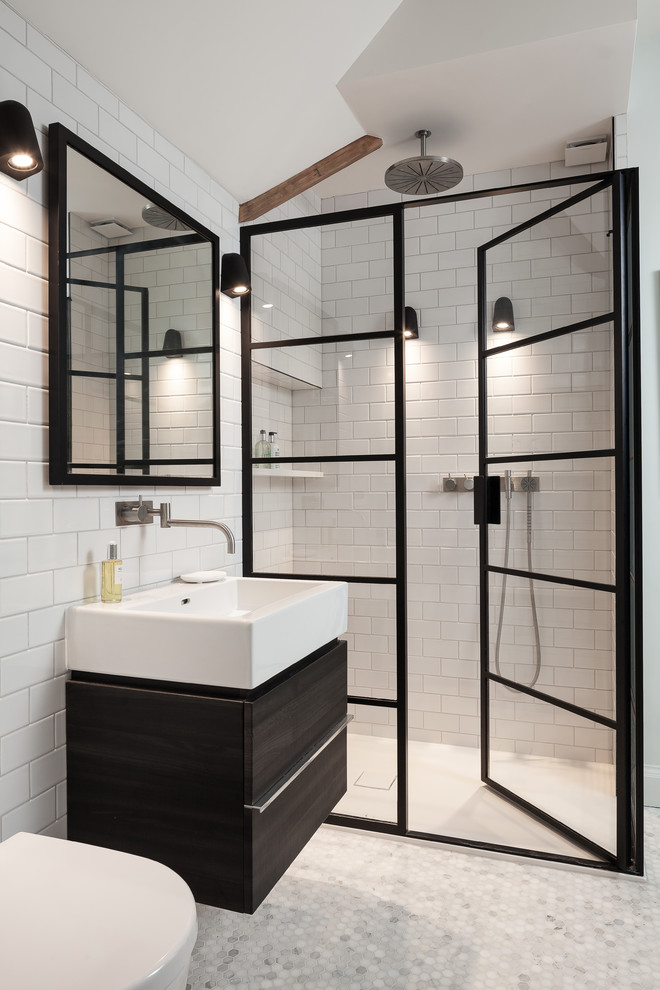 Bild på ett funkis badrum med dusch, med släta luckor, svarta skåp, en dusch i en alkov, en vägghängd toalettstol, tunnelbanekakel, vita väggar, mosaikgolv, ett fristående handfat, träbänkskiva och dusch med gångjärnsdörr