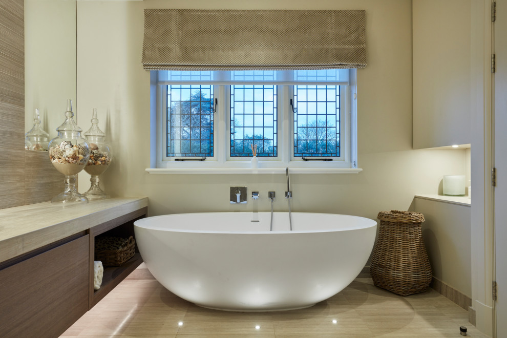 Свежая идея для дизайна: ванная комната в современном стиле с плоскими фасадами, фасадами цвета дерева среднего тона, отдельно стоящей ванной, бежевыми стенами, серым полом, серой столешницей и подвесной тумбой - отличное фото интерьера