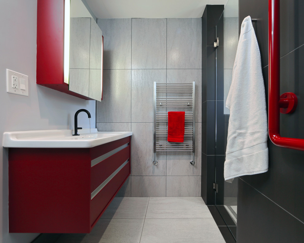 Inredning av ett modernt litet en-suite badrum, med ett väggmonterat handfat, släta luckor, röda skåp, en vägghängd toalettstol, svart kakel, porslinskakel, klinkergolv i porslin och grå väggar