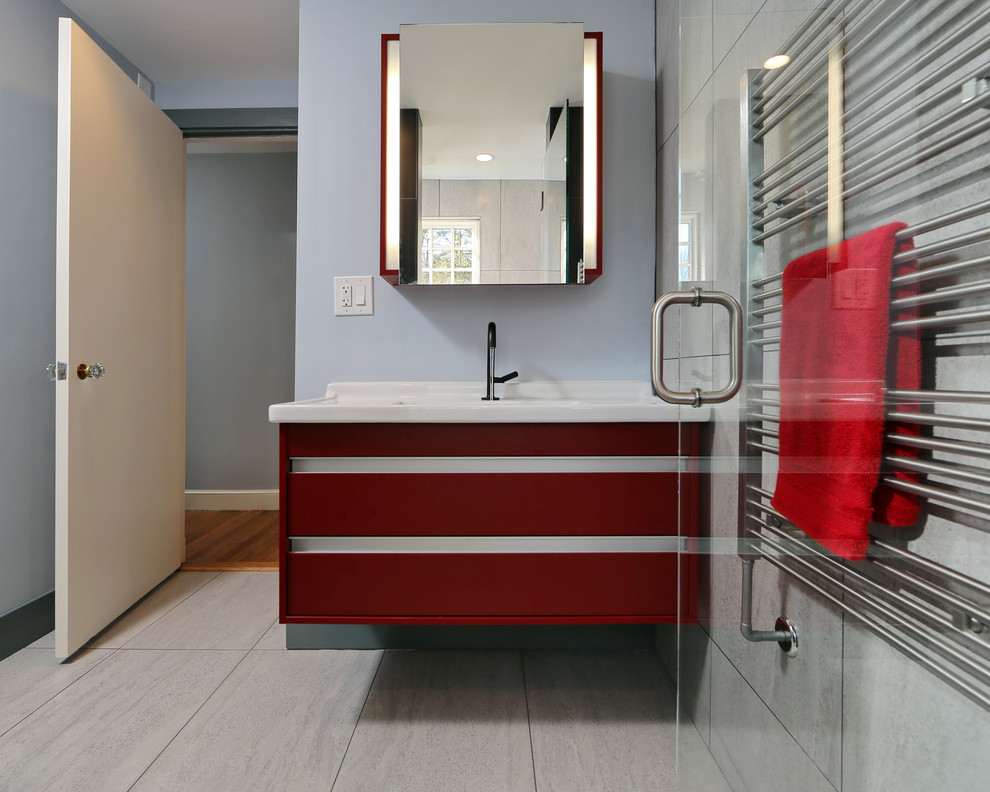 Photo of a small modern ensuite bathroom in Boston with a wall-mounted sink, flat-panel cabinets, red cabinets, a wall mounted toilet, black tiles, porcelain tiles, porcelain flooring and blue walls.