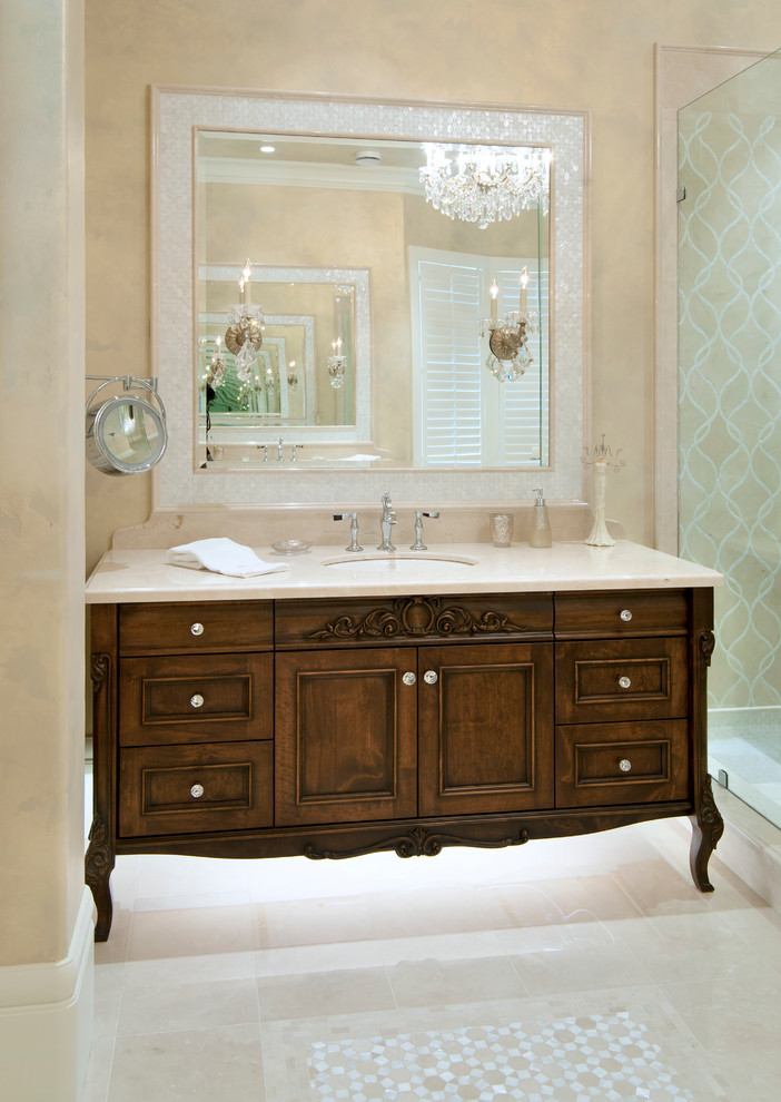 Modelo de cuarto de baño tradicional con lavabo bajoencimera, puertas de armario de madera en tonos medios, ducha empotrada, baldosas y/o azulejos beige, paredes beige y armarios con paneles empotrados