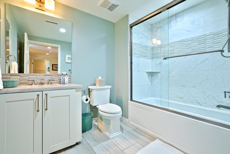 Exemple d'une petite salle de bain bord de mer avec un combiné douche/baignoire, WC séparés, un carrelage gris, un carrelage de pierre, un mur beige, un lavabo encastré et un plan de toilette en quartz modifié.