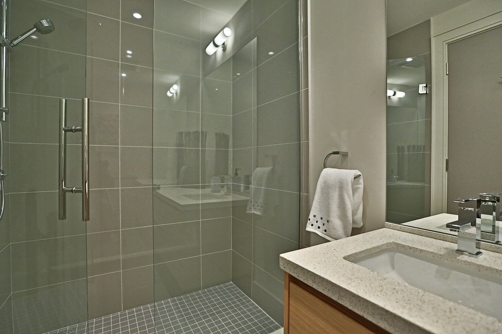 Ispirazione per una stanza da bagno con doccia minimalista di medie dimensioni con ante lisce, ante in legno scuro, doccia alcova, pareti beige, lavabo sottopiano e porta doccia a battente