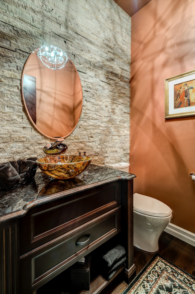 Foto di una stanza da bagno con doccia tradizionale di medie dimensioni con lavabo a bacinella, ante con riquadro incassato, ante in legno bruno, top in granito, WC monopezzo, piastrelle in pietra, pareti arancioni e parquet scuro