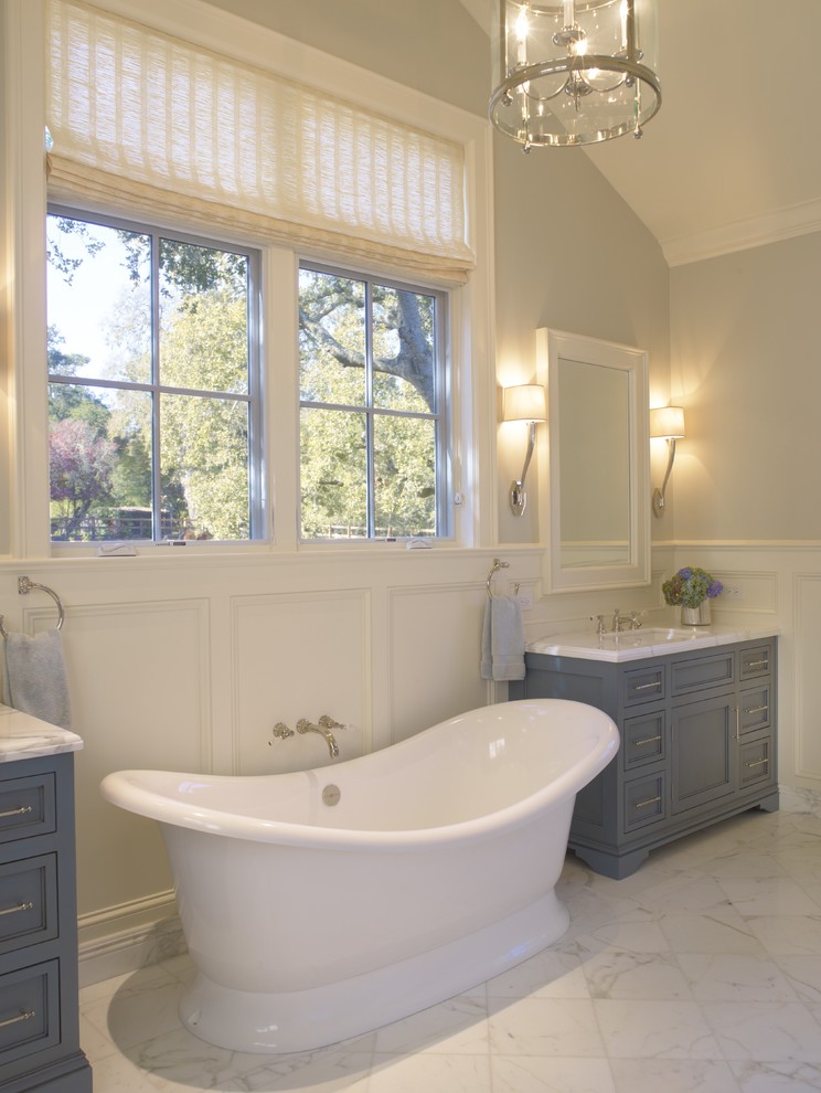 Пример оригинального дизайна: ванная комната: освещение в классическом стиле с отдельно стоящей ванной и синими фасадами