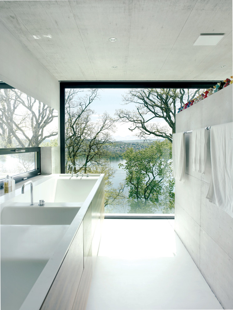 Contemporary ensuite bathroom in London with a trough sink and a submerged bath.