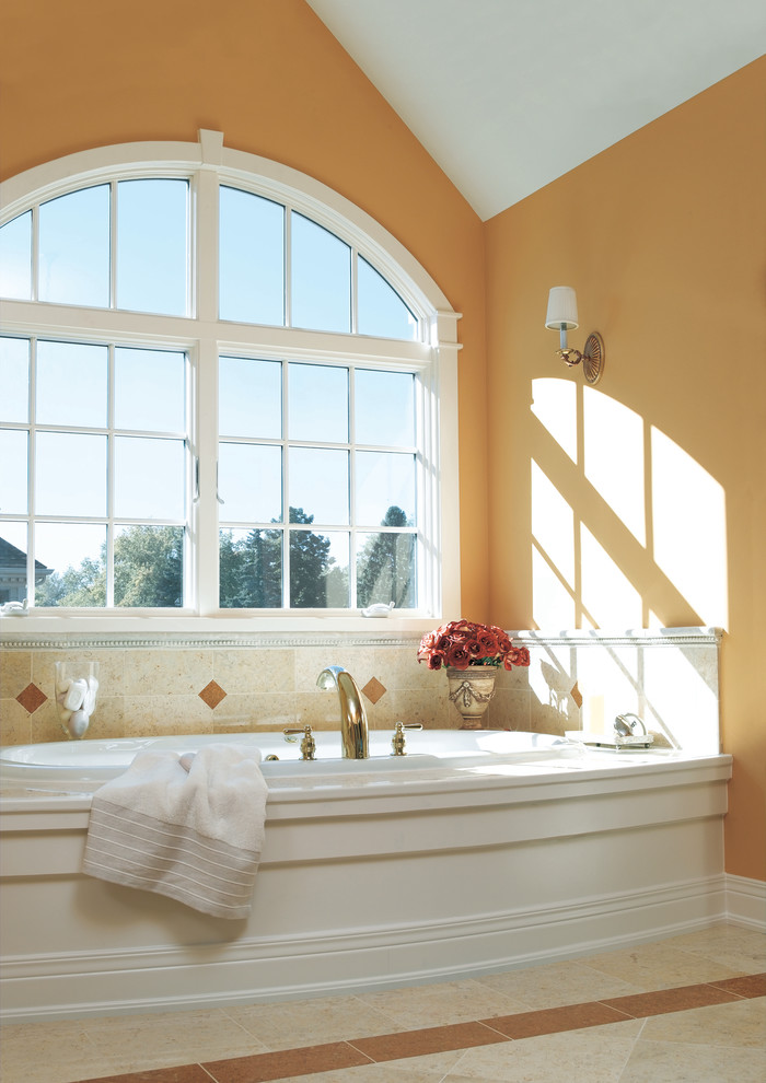 Inredning av ett modernt stort en-suite badrum, med ett hörnbadkar, orange väggar, beige kakel och perrakottakakel