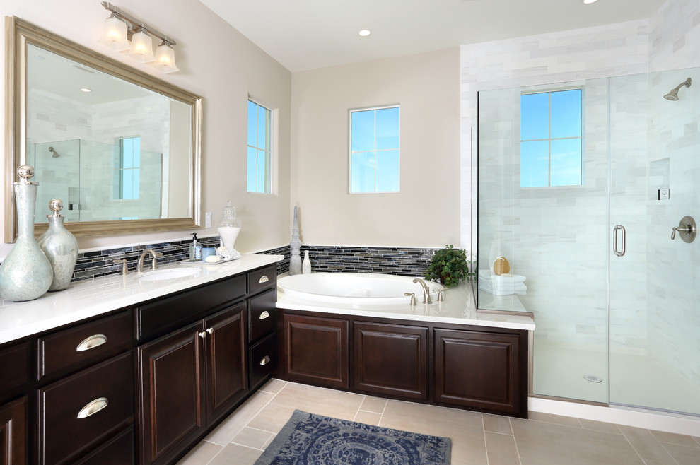 Exemple d'une salle de bain principale bord de mer en bois brun de taille moyenne avec un lavabo encastré, un placard avec porte à panneau surélevé, un plan de toilette en quartz modifié, une baignoire posée, un carrelage bleu, un mur beige et un sol en carrelage de céramique.