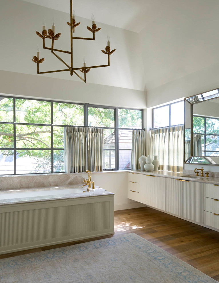 This is an example of a large traditional ensuite bathroom in Dallas with freestanding cabinets, white cabinets, a built-in bath, white walls, medium hardwood flooring, a wall-mounted sink and marble worktops.
