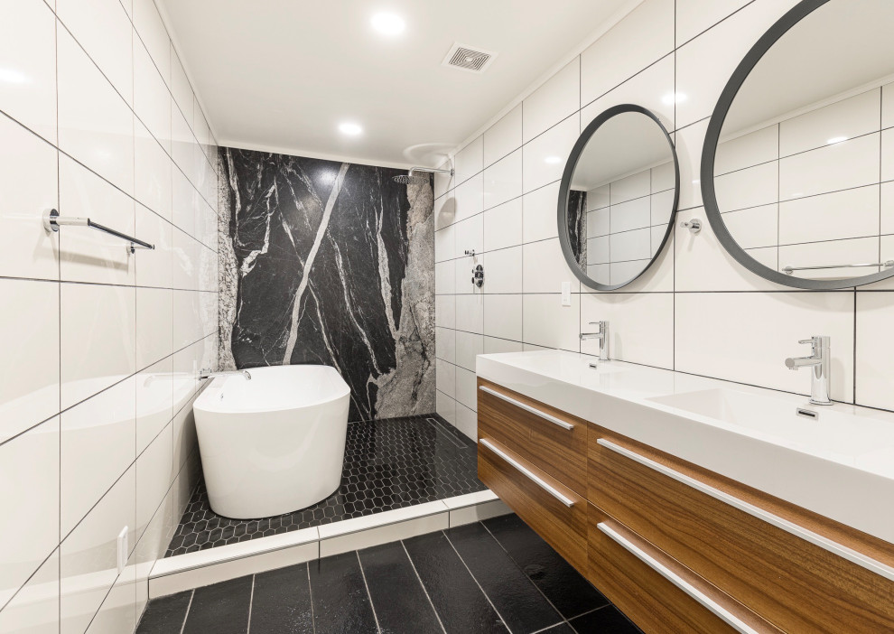 Inspiration för stora moderna vitt en-suite badrum, med släta luckor, skåp i mellenmörkt trä, ett fristående badkar, en dusch/badkar-kombination, svart och vit kakel, ett integrerad handfat, svart golv och med dusch som är öppen