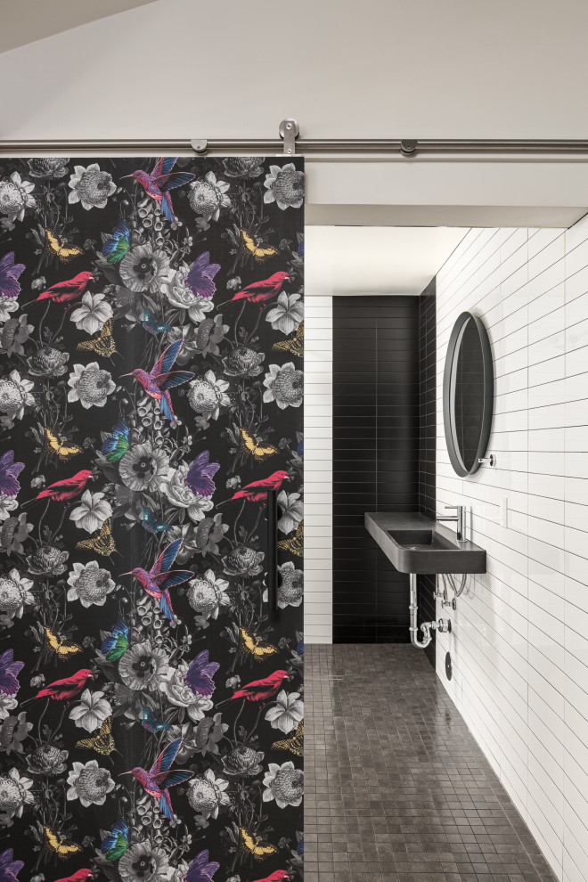 Immagine di una stanza da bagno minimalista di medie dimensioni con doccia aperta, piastrelle bianche, top in cemento, top nero, un lavabo e mobile bagno sospeso
