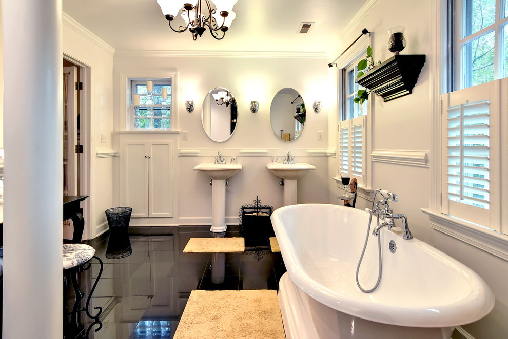 Freestanding bathtub - traditional black floor freestanding bathtub idea in Other with a pedestal sink and white walls