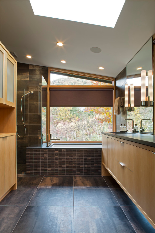 Photo of a large contemporary ensuite bathroom in Charlotte with a submerged bath, granite worktops, flat-panel cabinets, beige cabinets, black tiles, ceramic tiles, beige walls, ceramic flooring, an integrated sink and brown floors.