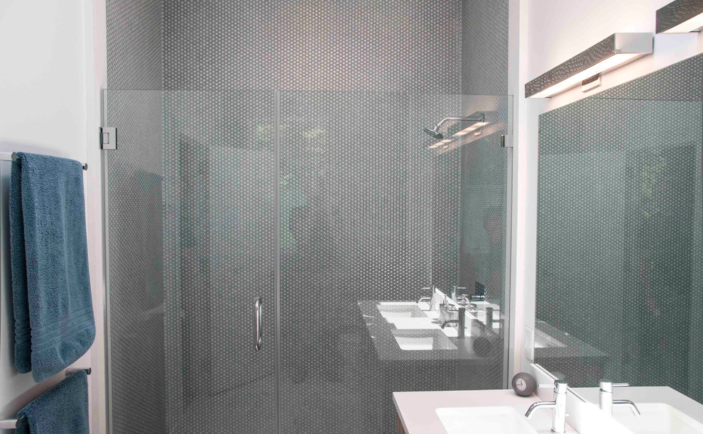 Ejemplo de cuarto de baño contemporáneo con lavabo tipo consola, armarios con paneles lisos, puertas de armario de madera en tonos medios, bañera encastrada, ducha doble, sanitario de una pieza, baldosas y/o azulejos grises y baldosas y/o azulejos en mosaico