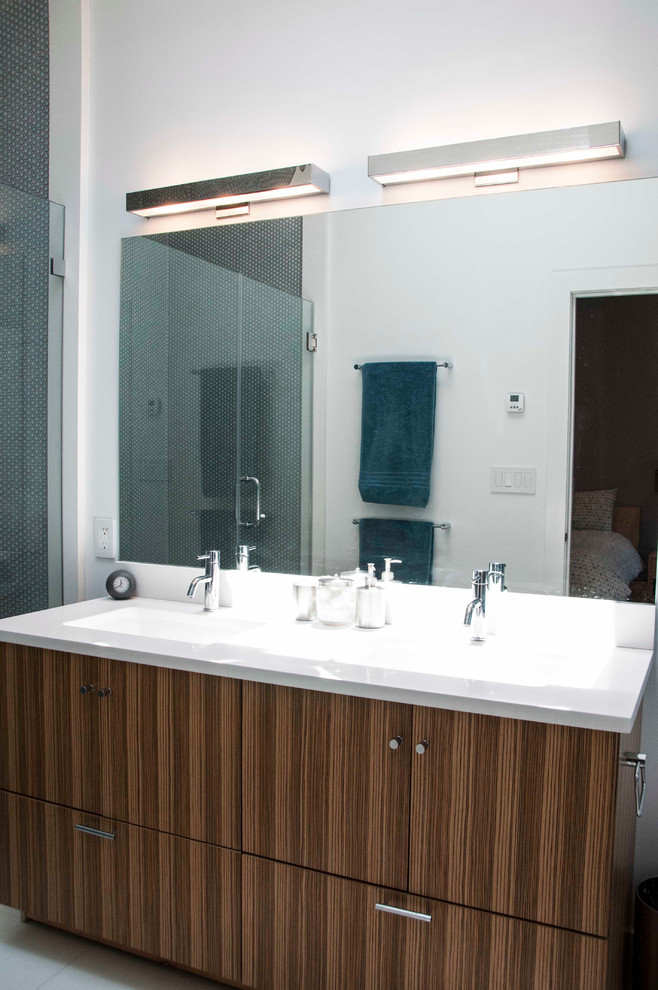 Ispirazione per una stanza da bagno minimal con lavabo a consolle, ante lisce, ante in legno bruno, vasca da incasso, doccia doppia, WC monopezzo e piastrelle di vetro