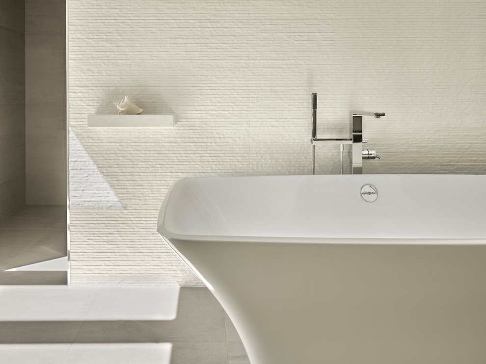 Foto de cuarto de baño principal contemporáneo con bañera exenta y baldosas y/o azulejos blancos