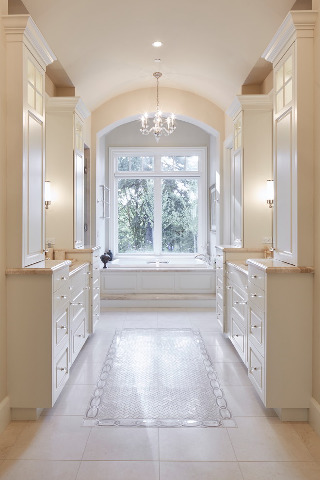 Example of a large classic master beige floor drop-in bathtub design in Portland with raised-panel cabinets, white cabinets, black walls, an undermount sink and granite countertops
