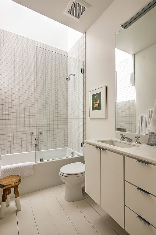 Landhausstil Badezimmer mit Unterbauwaschbecken, weißen Schränken, Duschbadewanne, Wandtoilette mit Spülkasten, weißer Wandfarbe und hellem Holzboden in San Francisco