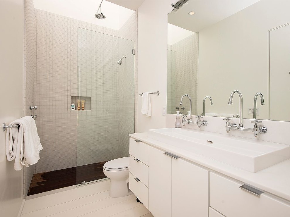 This is an example of a medium sized farmhouse bathroom in San Francisco with flat-panel cabinets, white cabinets, white walls and light hardwood flooring.
