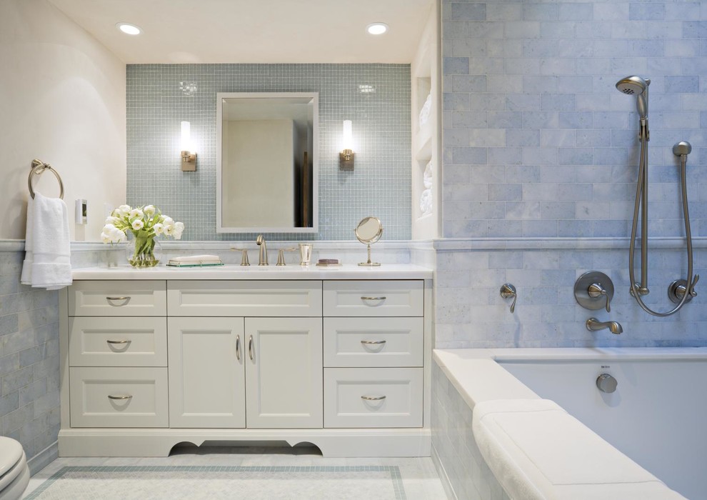 На фото: ванная комната в классическом стиле с врезной раковиной, фасадами с утопленной филенкой, белыми фасадами, ванной в нише, синей плиткой и плиткой мозаикой