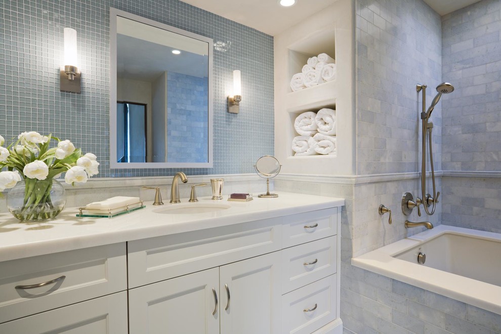Medium sized classic ensuite bathroom in San Francisco with shaker cabinets, white cabinets, a shower/bath combination, stone tiles, a submerged sink, solid surface worktops, an open shower and blue tiles.