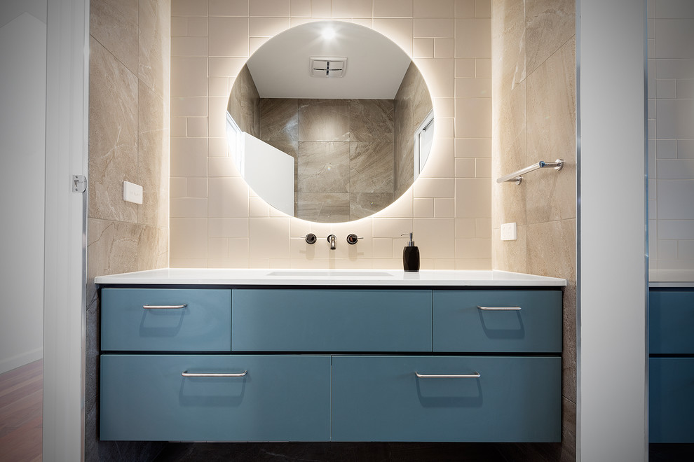 Modelo de cuarto de baño principal actual de tamaño medio con armarios con paneles lisos, puertas de armario azules, baldosas y/o azulejos amarillos, baldosas y/o azulejos de piedra y encimera de esteatita