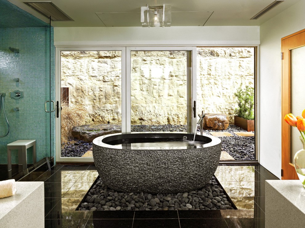 Inspiration for a mid-sized contemporary master black tile and stone tile porcelain tile and black floor bathroom remodel in Austin with white walls, a vessel sink, solid surface countertops, a wall-mount toilet and a hinged shower door