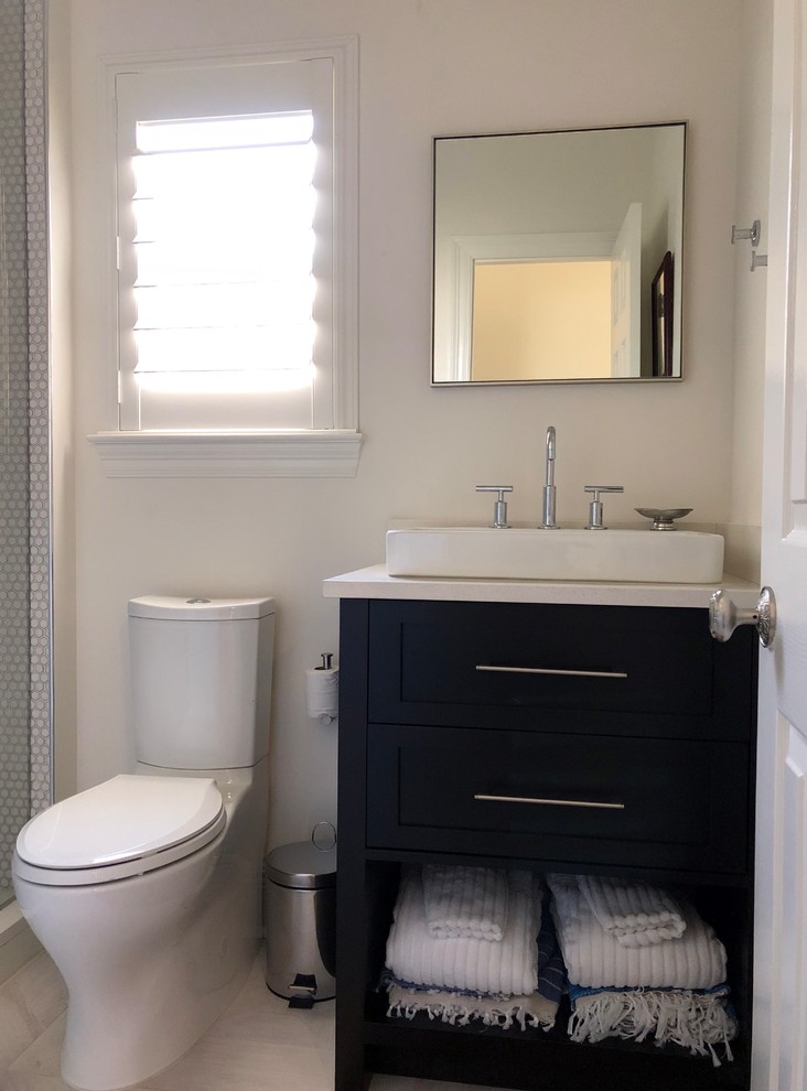 Bild på ett litet funkis badrum med dusch, med skåp i shakerstil, skåp i mörkt trä, en dusch i en alkov, en toalettstol med hel cisternkåpa, vit kakel, keramikplattor, vita väggar, klinkergolv i keramik, ett fristående handfat, bänkskiva i kvarts, grått golv och dusch med gångjärnsdörr