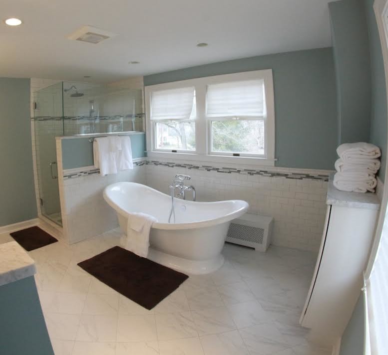 Cette image montre une salle de bain principale traditionnelle avec un lavabo encastré, un placard avec porte à panneau encastré, des portes de placard blanches, un plan de toilette en marbre, une baignoire indépendante, WC à poser, un carrelage blanc, un carrelage métro, un mur bleu, un sol en carrelage de porcelaine et une douche d'angle.