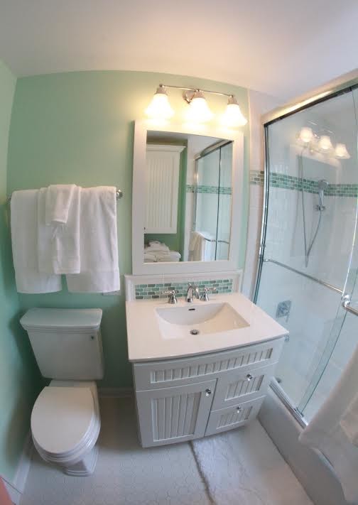Small classic family bathroom in Chicago with an integrated sink, shaker cabinets, white cabinets, an alcove bath, an alcove shower, a two-piece toilet, white tiles, ceramic tiles, green walls and ceramic flooring.