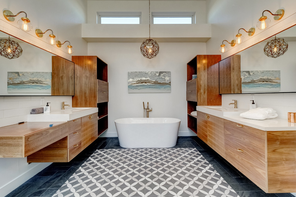 Inredning av ett modernt grå grått en-suite badrum, med släta luckor, skåp i mellenmörkt trä, ett fristående badkar, beige väggar, ett integrerad handfat, bänkskiva i betong och flerfärgat golv