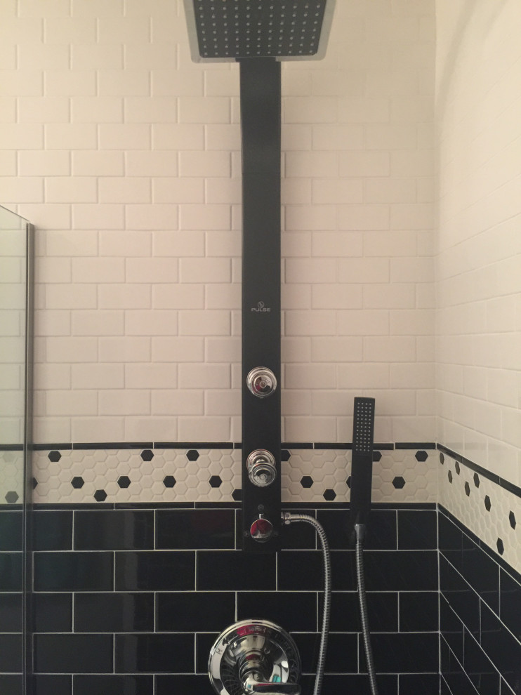 Foto på ett mellanstort eklektiskt vit badrum med dusch, med skåp i shakerstil, svarta skåp, en öppen dusch, en toalettstol med separat cisternkåpa, svart och vit kakel, keramikplattor, vita väggar, klinkergolv i keramik, ett undermonterad handfat, bänkskiva i akrylsten, svart golv och med dusch som är öppen