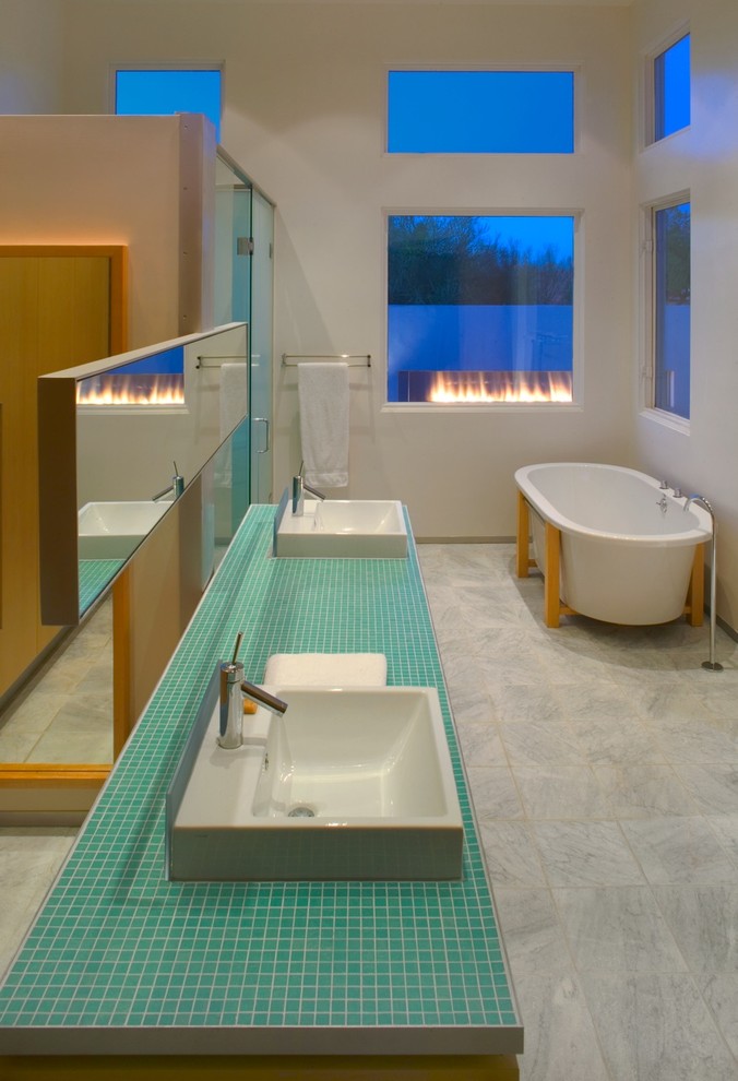 Свежая идея для дизайна: ванная комната в стиле модернизм с настольной раковиной, столешницей из плитки, отдельно стоящей ванной, синей плиткой и белыми стенами - отличное фото интерьера