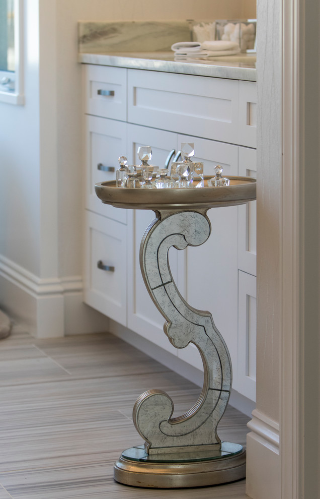 Modelo de cuarto de baño principal costero de tamaño medio con armarios estilo shaker, puertas de armario blancas, paredes beige, suelo de baldosas de cerámica y encimera de mármol