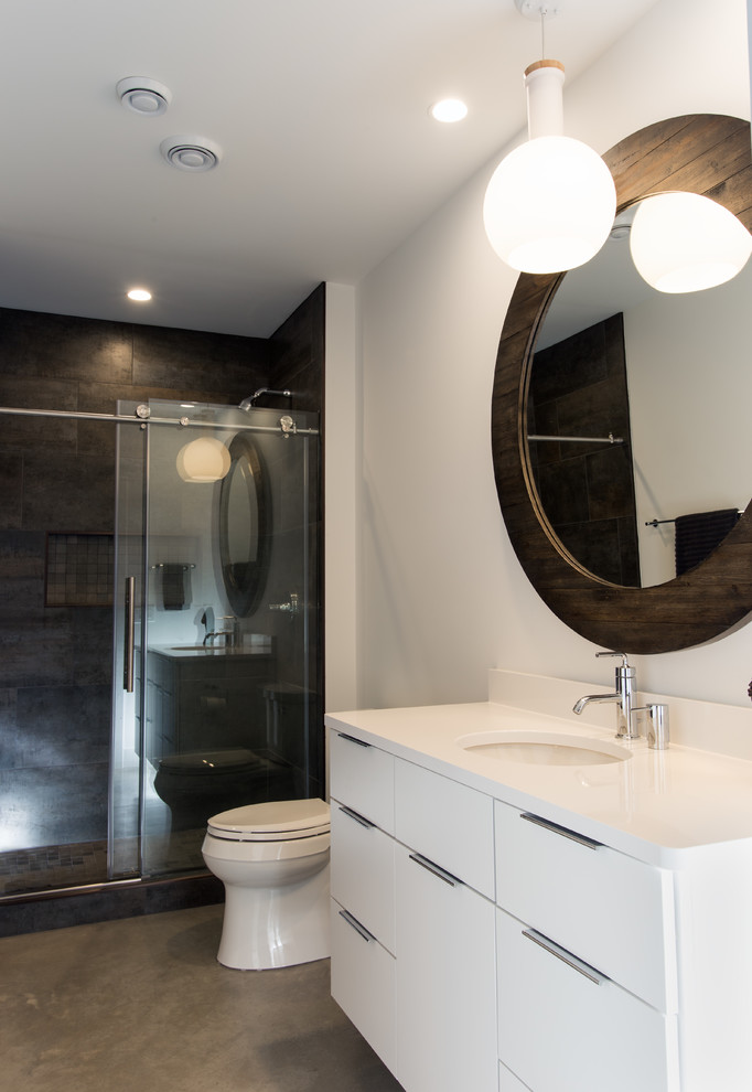 Inspiration for a modern 3/4 black tile and porcelain tile concrete floor and gray floor bathroom remodel in Other with flat-panel cabinets, white cabinets, a two-piece toilet, white walls, an undermount sink, solid surface countertops and yellow countertops